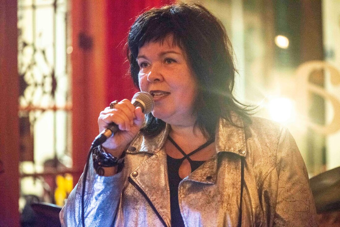 Zangeres solo met microfoon onder zacht podiumlicht