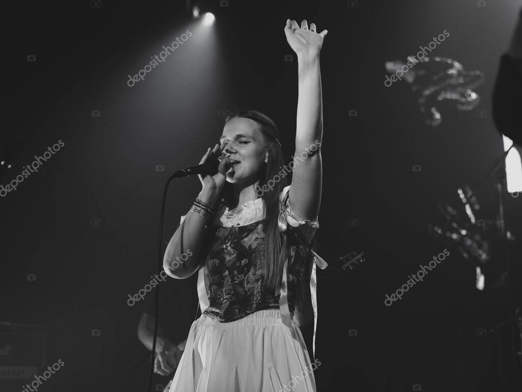 Vrouwelijke zangeres op podium met publiek en spotlights